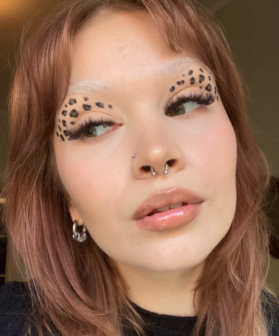Nainen jonka kasvoille on tehty leopardimeikki värikkäillä eyelinereilla.